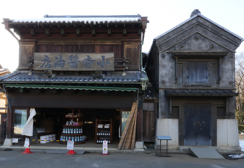小寺醤油店(こでらしょうゆてん)|江戸東京たてもの園 1933年(昭和8) 港区白金五丁目 大正期から、現在の港区白金で営業していた店です。味噌や醤油、酒類を売っていました。 庇の下の腕木とその上の桁が特徴の〈出桁造り(だしげたづくり)〉がこの建物のみどころです。
