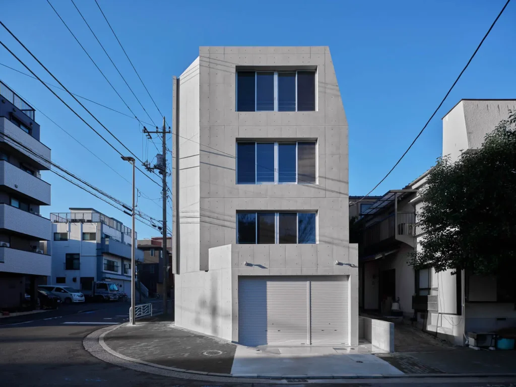 コスト削減と明るい採光を両立したRC造4階建て自社ビルの外観。1階に倉庫を備えた都内のオフィス建築事例です。