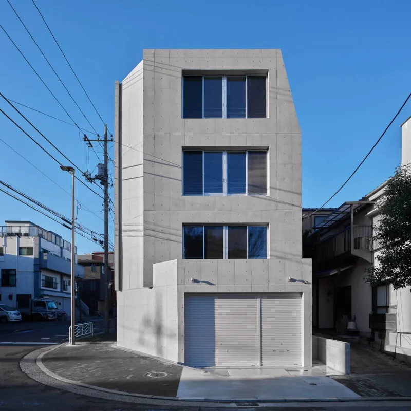 コスト削減と明るい採光を両立したRC造4階建て自社ビルの外観。1階に倉庫を備えた都内のオフィス建築事例です。