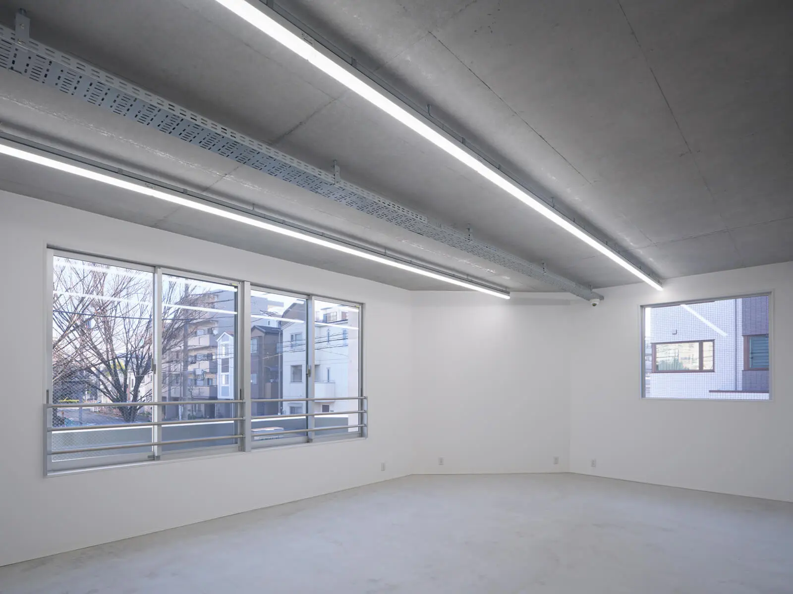 建築費を削減したRC造オフィス内観。OAフロアを廃止して天井配線ラックを採用し、無駄を省いた合理的な設計です。