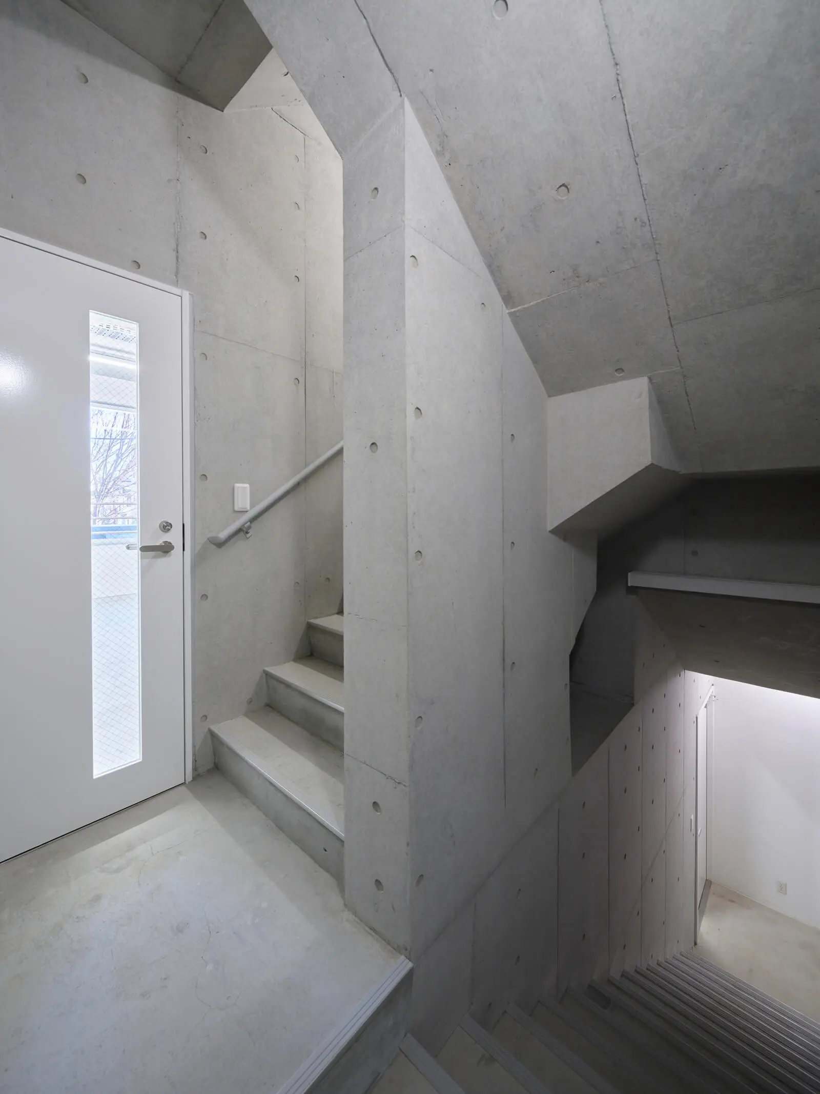 江東区潮見の中小企業向け自社ビル設計事例。重厚感のあるコンクリート打放し仕上げの美しい階段室です。