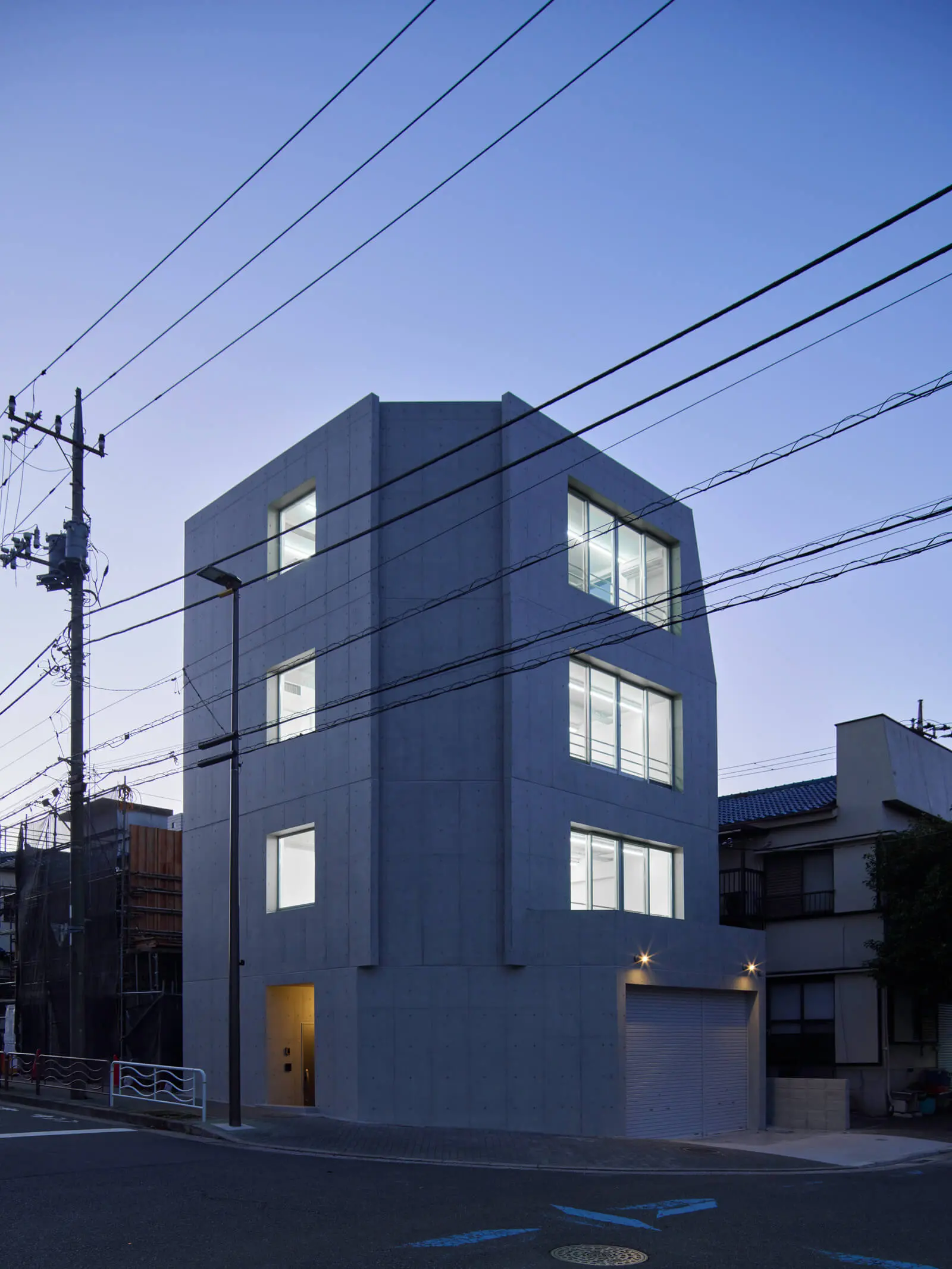 不要なコンクリートを削ぎ落とし軽量化を図ったRC造自社ビル・オフィスの南東外観夕景。江東区潮見の事例。