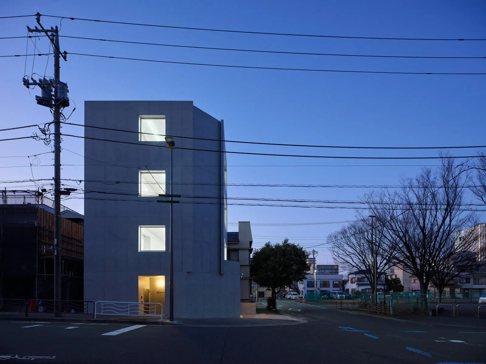 隣接する公園の緑と調和する江東区潮見のRC造4階建てオフィスビル。借景を活かした南側外観の美しい夕景。