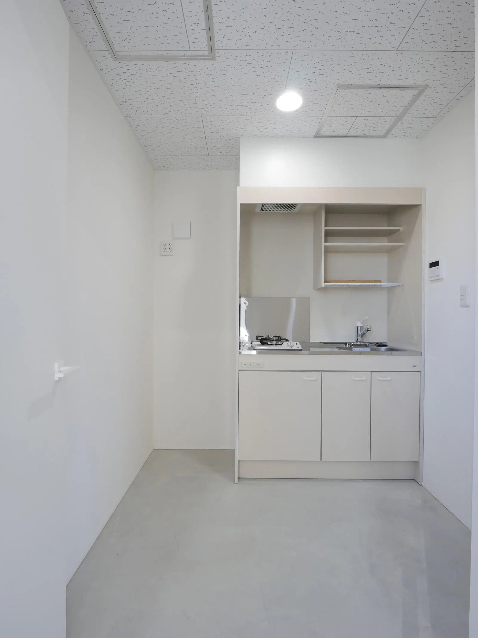 メンテナンス性に優れたジプトン天井を採用した、自社ビル3階の機能的な給湯室（ガス台付き）。