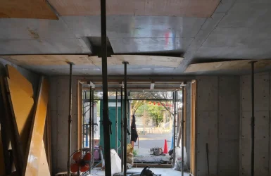 江東区潮見の4階建てオフィスビル設計事例。3階壁鉄筋工事中の1階は型枠が脱型され支保工パイプサポートが天井支持が残っています。