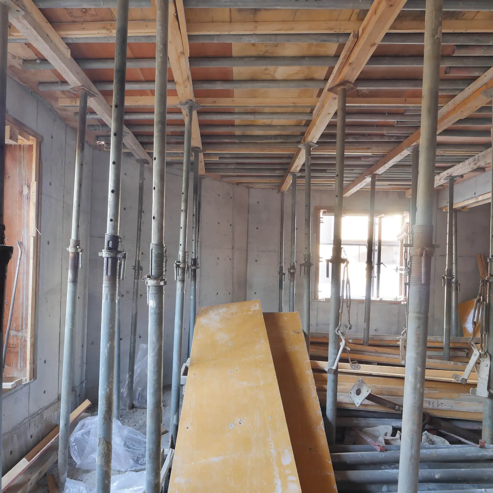 江東区潮見で施工中のコンクリート打放し仕上4階建てオフィスビル2階の型枠脱型後の内部空間 壁とスラブ下の施工状況が分かる現場写真