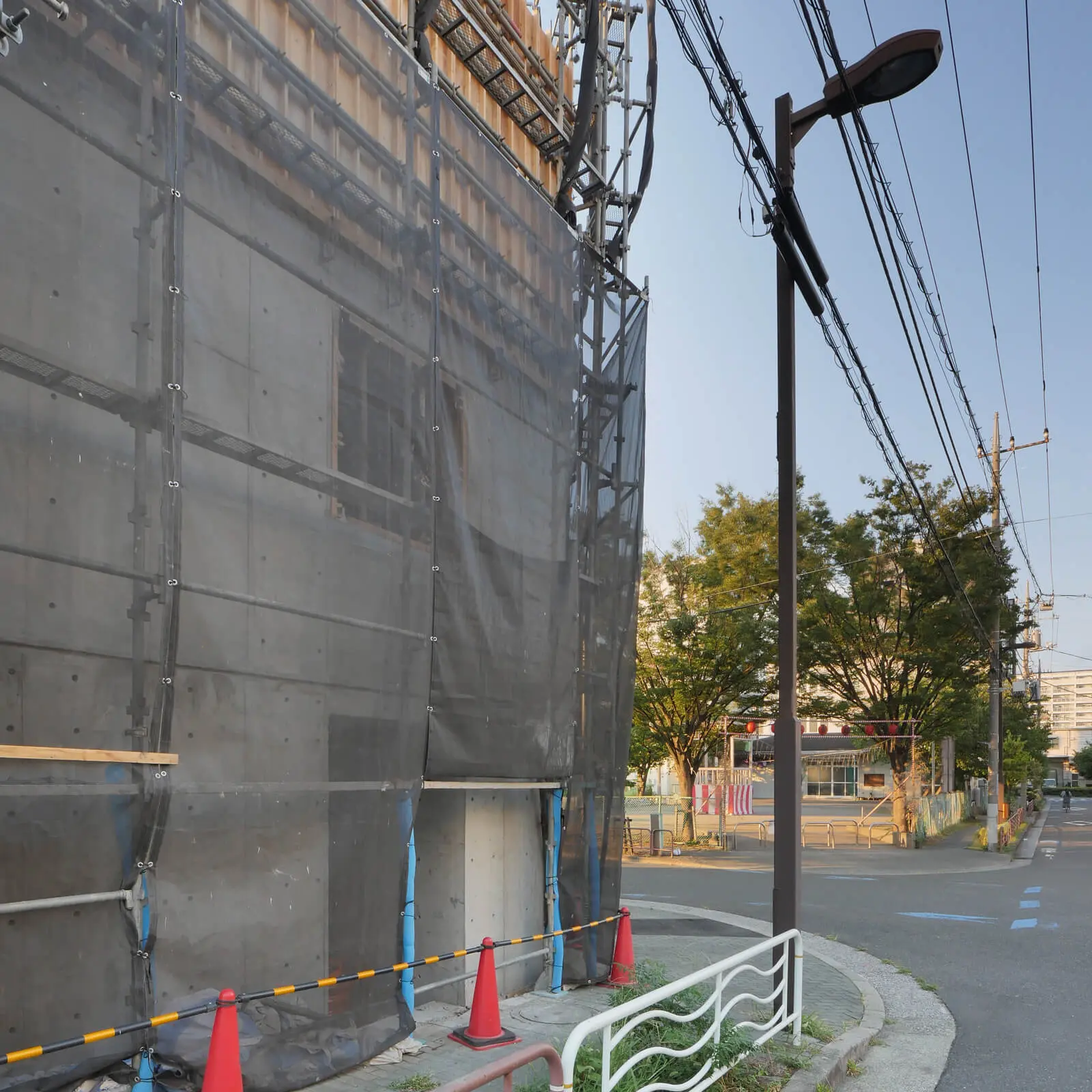 オフィスビルの南側エントランス。打ち放しコンクリートのセパレーターの割り付けが美しい壁面。