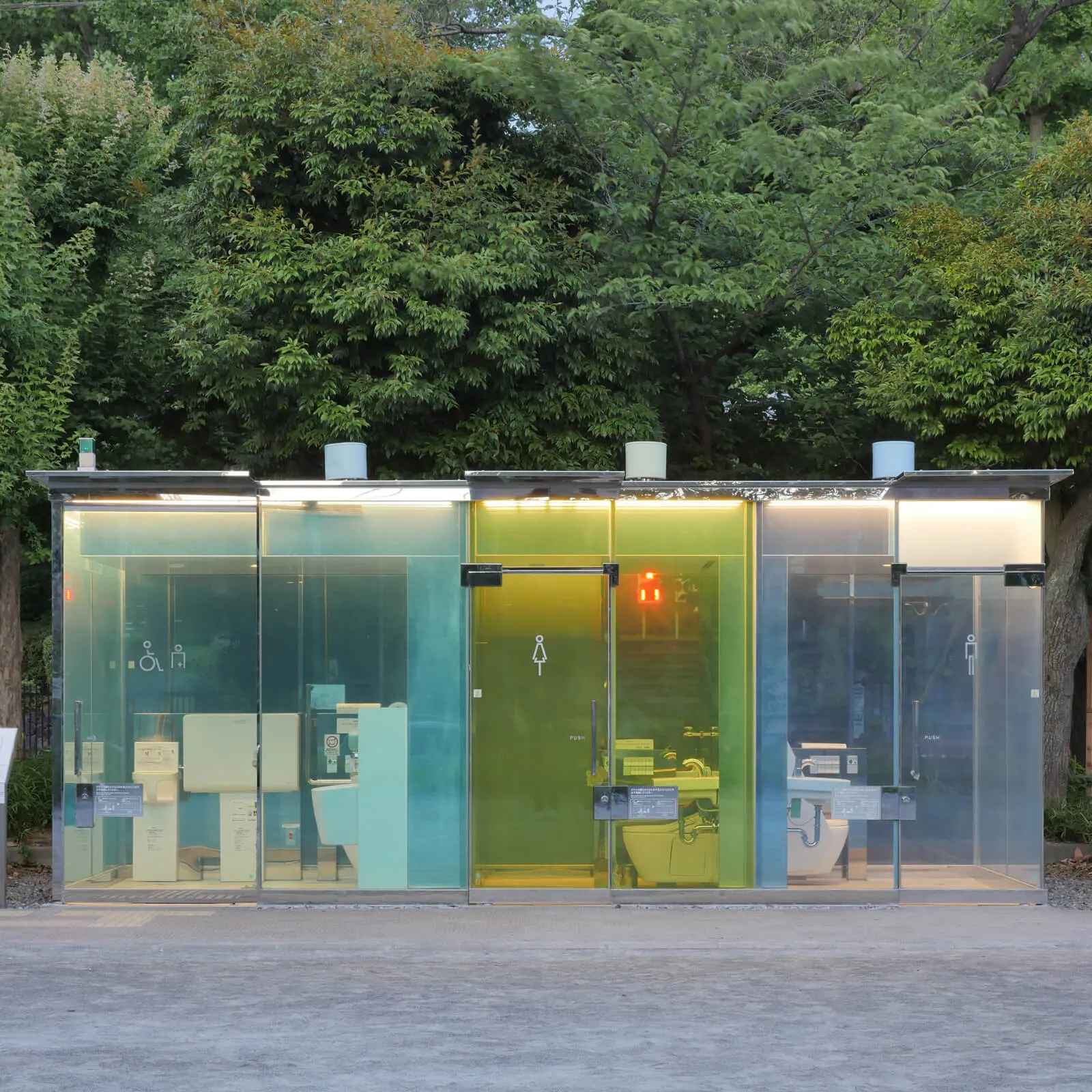 THE TOKYO TOILET 坂茂設計 はるのおがわコミュニティパーク 透明トイレ正面外観 夜景 行灯のように発光し安全性を高めるデザイン