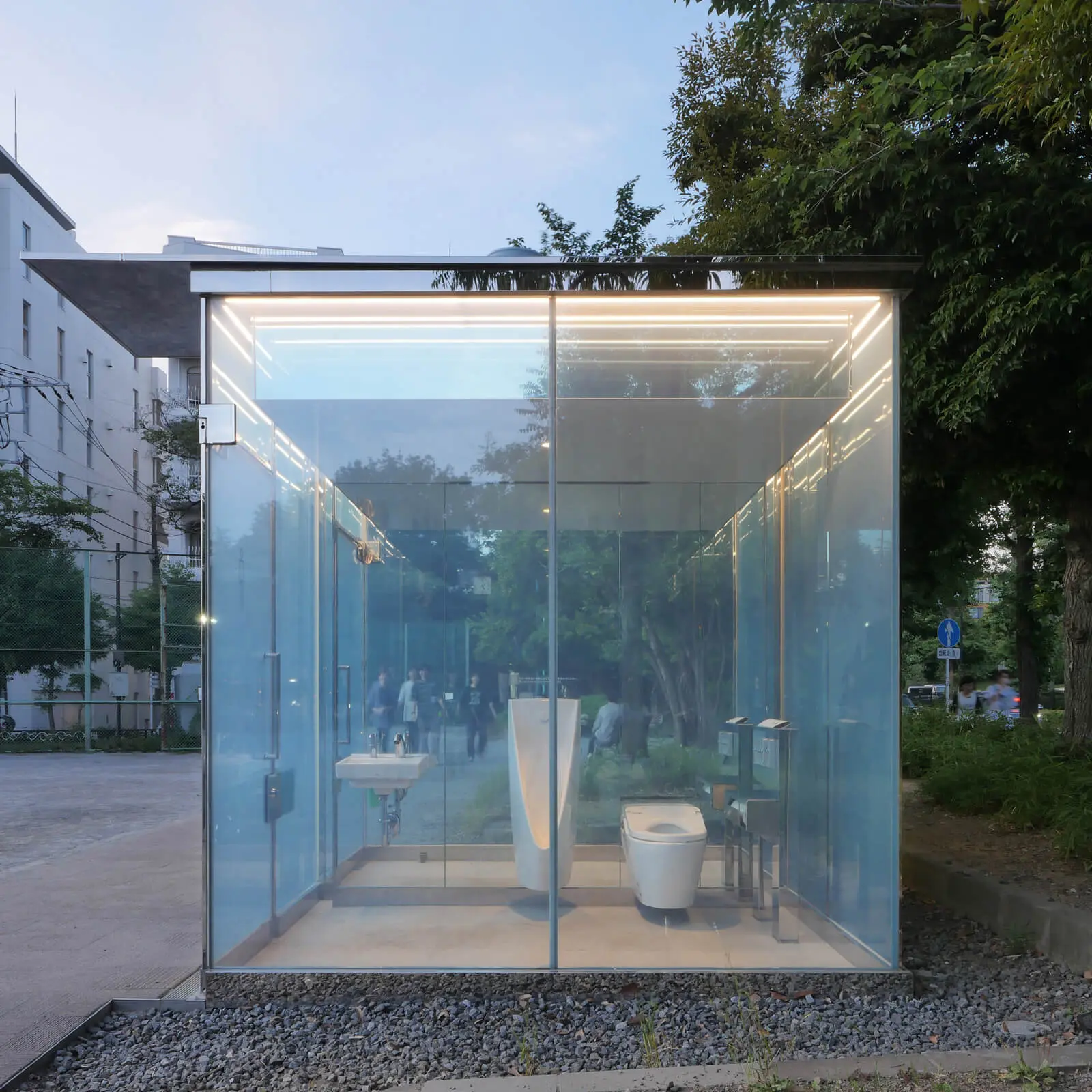 坂茂建築設計による透明トイレの男子トイレ側側面外観。青や黄色のカラーフィルムとステンレス鏡面サッシが特徴的な公共建築デザイン。