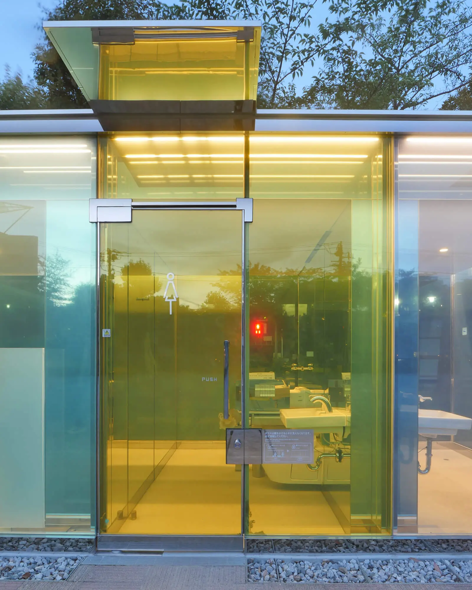 はるのおがわコミュニティパークの透明トイレ、女子トイレの外観正面。夜には行灯のように公園を照らす、坂茂設計の美しい公共トイレ。