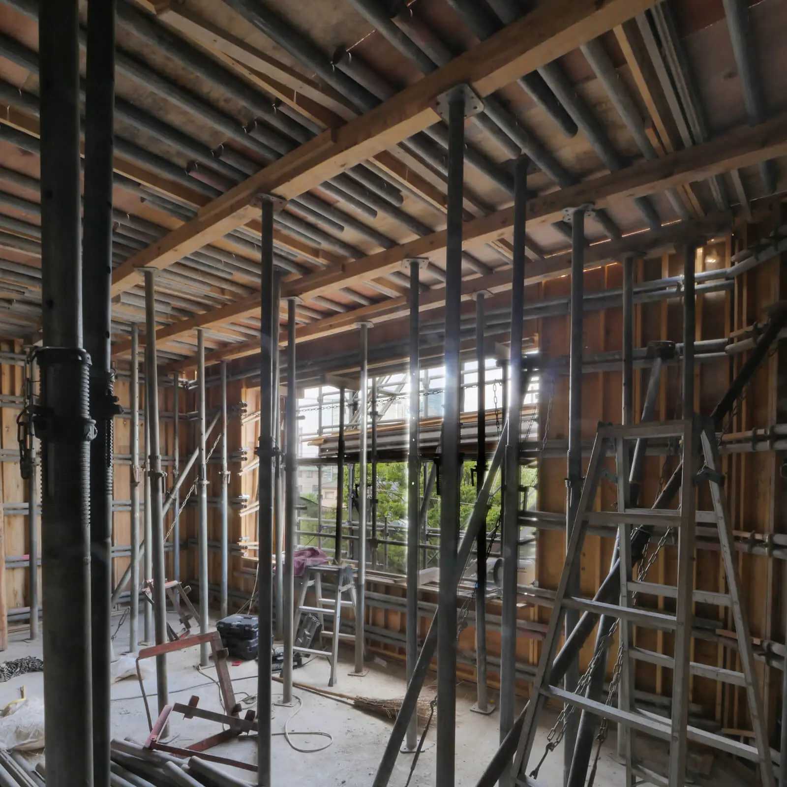 RC造4階建てオフィスビル(東京都江東区潮見)3階事務室の型枠施工状況、南西側から北東側を見る。東側開口部からは道路向かいの公園の樹木が窓いっぱいに広がる
