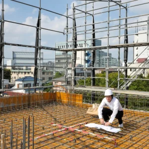 一級建築士・設計監理者 片岡直樹が構造図と照合しながら配筋ピッチを計測する4階床配筋検査の様子(東京都江東区潮見のRC造4階建てオフィスビル)