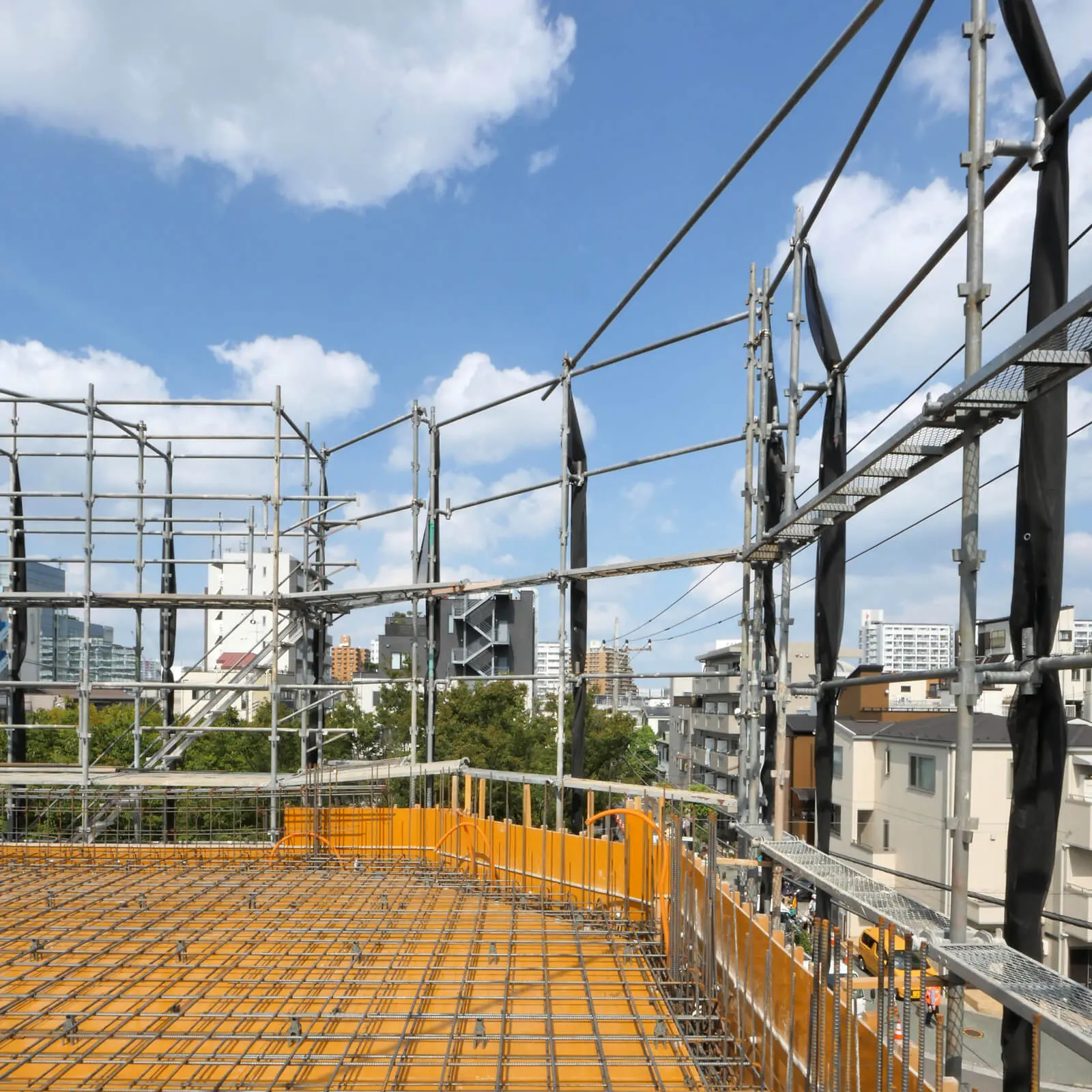 江東区潮見のRC造4階建てオフィスビル新築工事、4階床(会議室部分)配筋工事の様子(西から東を見る、奥に公園の樹木)
