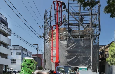 東京都江東区で建設中の鉄筋コンクリート造・コンクリート打放し仕上げ4階建てオフィスビル。東側外観。コンクリート圧送ポンプ車と生コンクリートミキサー車によるコンクリート打設の様子。