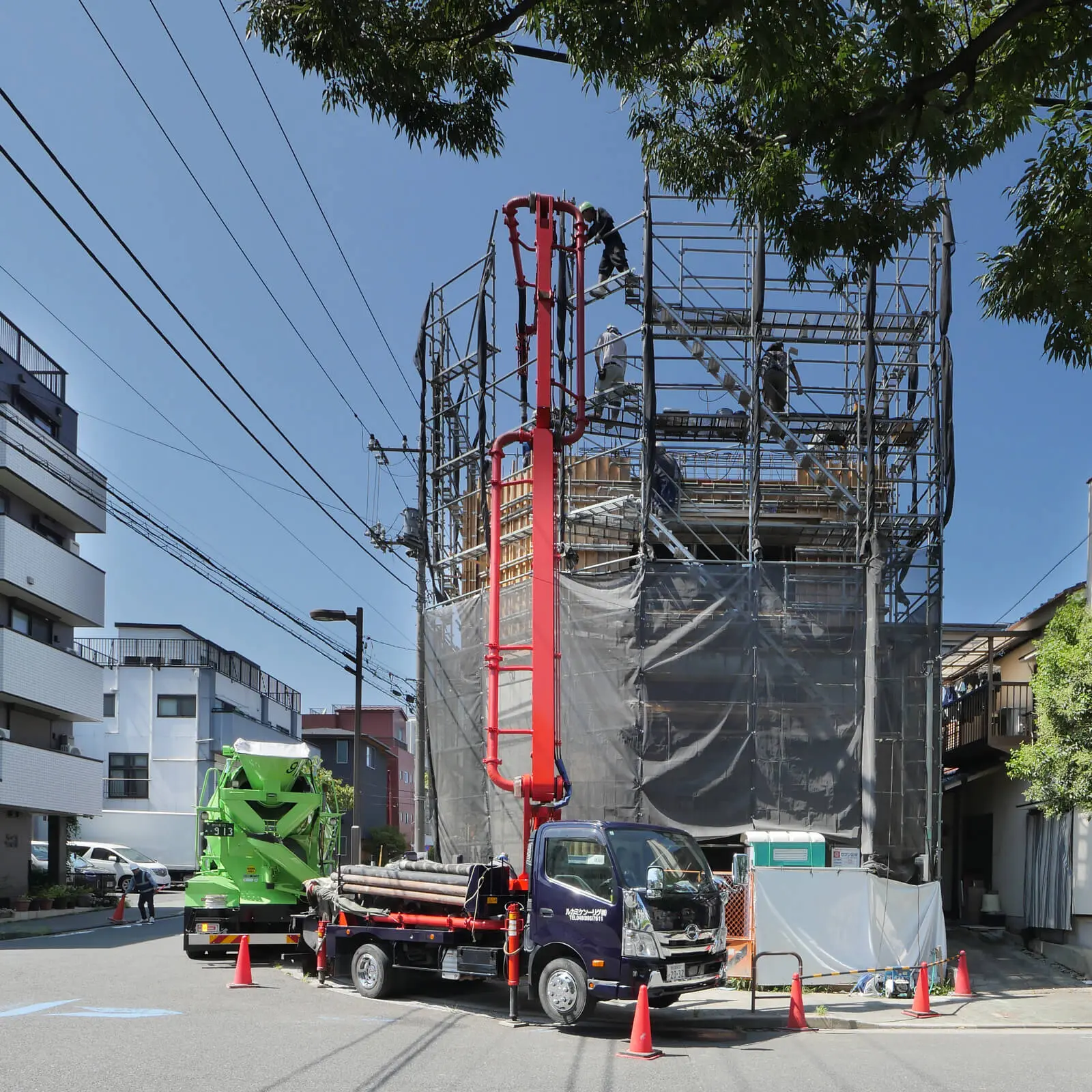 東京都江東区で建設中の鉄筋コンクリート造・コンクリート打放し仕上げ4階建てオフィスビル。東側外観。コンクリート圧送ポンプ車と生コンクリートミキサー車によるコンクリート打設の様子。