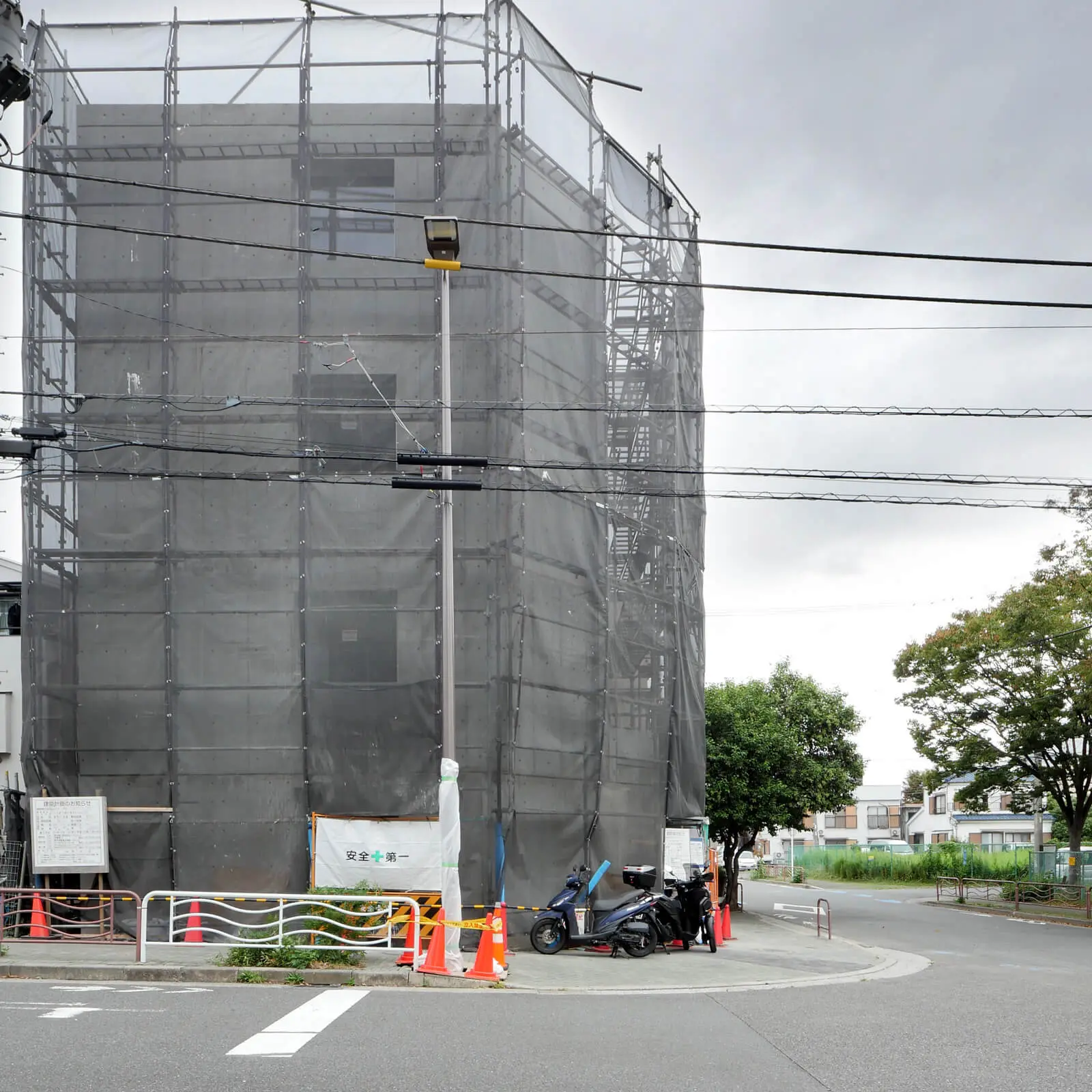 サッシとガラスが取り付けられた南側外観。交差点の角地に建つRC造4階建てオフィスビル
